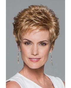 Woman in a petite strawberry blonde pixie wig with curled spiky layering on top and fringe bangs