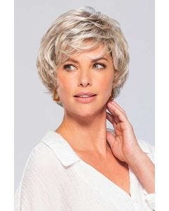 Woman in short red wavy wig with layers, bangs and sideburns for an older woman