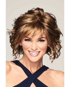 Woman in a past the chin length dark blonde layered curly wig with fringe bangs