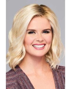 Woman in a shoulder length blonde wig with choppy layers