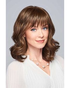 Woman in a shoulder length golden brown curly wig with textured bangs