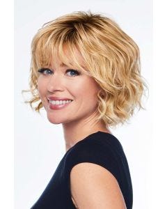 Woman in a shoulder length dark blonde wavy wig with fringe bangs