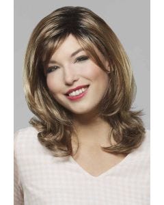 Woman in long, slightly wavy layered light brown wig with long face framing bangs