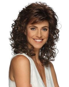 Woman in a past the shoulders dark auburn curly wig with wispy side bangs