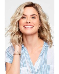 Woman in a petite shoulder length light blonde curly lace front wig