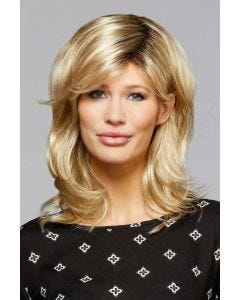 Woman in a shoulder length gold blonde wavy wig with flipped out ends and side swept bangs