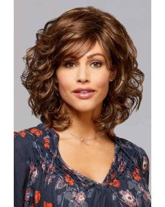 Woman in a medium brown curly wig with ample volume and side swept bangs