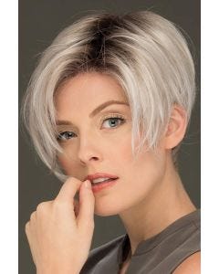 Woman in an asymmetric platinum blonde stacked bob wig with dark roots