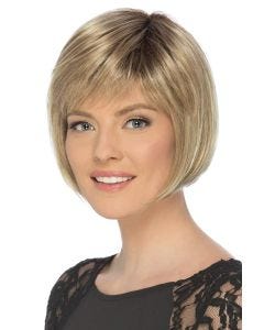 Woman in a chin length dark blonde blunt bob wig with fringe bangs