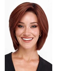 Woman in a chin length warm blonde wig with choppy layers and side bangs