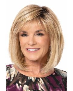 Woman in a shoulder length medium blonde bob wig with wispy bangs
