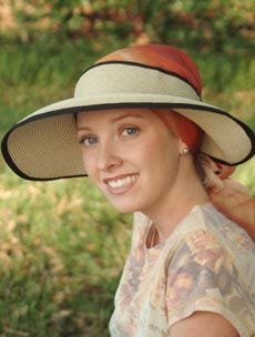 Woman outdoors wearing straw sun visor with head scarf underneath