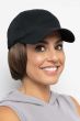 Woman in a solid black baseball cap with chin length light blonde hair attached