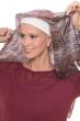 Woman in bamboo scarf pad beanie on head, worn under head scarves for body, shown tying a head scarf on top