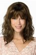 Woman in a past the shoulders wavy medium brown wig with fringe bangs