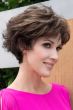 Woman in long light red textured pixie wig with longer layers at the top