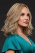 Woman in just past the shoulder wavy blonde wig with highlights and light layering