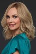 Woman in just past the shoulder wavy blonde wig with highlights and light layering