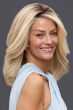 Woman in a past the shoulders medium auburn human hair wig with long layers