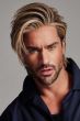 Man in a long light brown brushed back wig