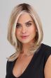 Woman in a straight, light brown and blonde wig with textured layering at the end and along the face