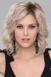Woman in a shoulder length curly platinum blonde wig with side bangs