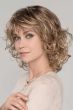 Woman in a shoulder length curly blonde wig with fringe bangs