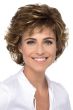 Woman in a chin length short medium brown wig with wispy bangs