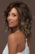 Woman in a past the shoulders curly light brown lace front wig with dark brown roots