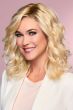 Woman in a shoulder length warm blonde curly wig
