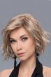 Woman in a chin length light blonde curly lace front wig