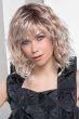 Woman in a shoulder length curly light blonde wig with side bangs