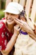 Woman with cancer in white newsboy hat hugging golden retriever
