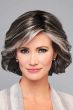 Woman in a chin length salt and pepper layered bob wig with side bangs