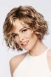 Woman in a chin length light brown curly lace front wig