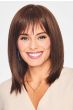 Woman in a past the shoulders straight medium brown wig with bangs