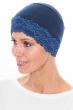 Woman in navy blue lace trimmed sleep cap in beanie style for women with cancer