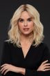 Woman in a shoulder length golden blonde curly remy human hair wig with dark roots