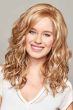 Woman in a past the shoulders curly light auburn lace front wig