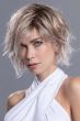 Woman in a chin length light blonde curly lace front wig