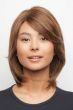 Woman in a shoulder length warm brown rounded bob wig with side bangs