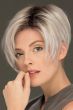 Woman in an asymmetric platinum blonde stacked bob wig with dark roots