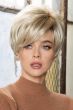 Woman in blonde short wig with longer layers and slight waves in back