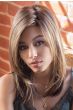 Woman in long straight dirty blonde wig with bangs and layers