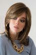 Woman in a past-the-shoulders, medium brown straight wig with long layers and side bangs