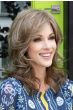 Woman in a past the shoulders curly dark auburn human hair wig