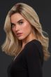 Woman in a long past the shoulders blonde wig with dark roots, barrel curls, and long layers