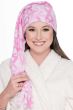 Woman wearing a pink breast cancer awareness ribbon print fleece elf sleep cap with a long tassel, styled with a white robe.