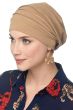 Woman in blue shirt and beige slouchy snood chemo hat