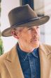 Older man in olive colored cool wool felt outback hat or fedora style brimmed hat